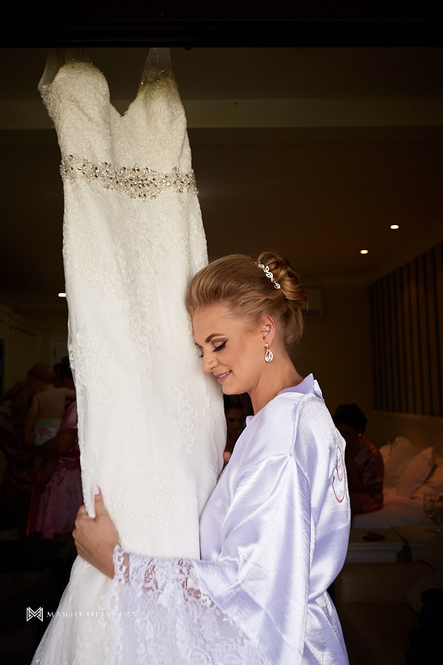 noiva de roupão de olhos fechados abraçando o vestido na varanda do hotel do making of
