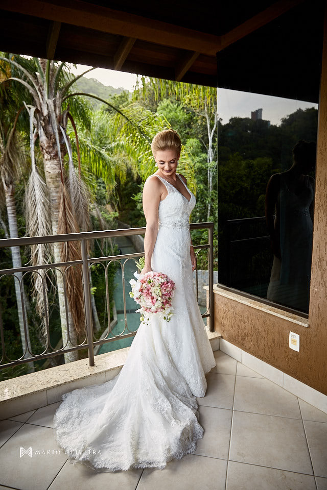 retrato da noiva em pé sorrindo segurando o buque