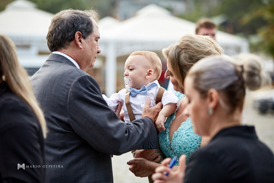 pai do noivo pegando bebe do colo da mãe da noiva