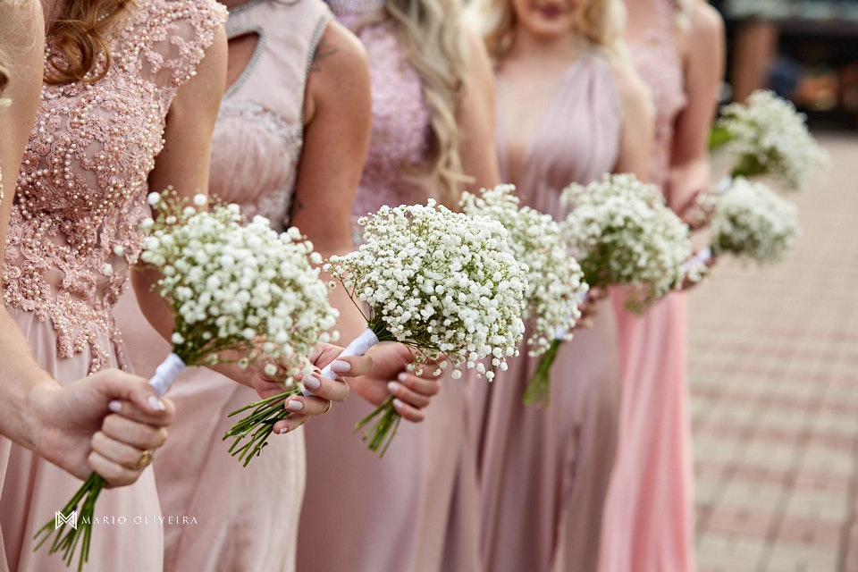 detalhe das mãos de cinco madrinhas com vestidos da mesma com segurando os buques