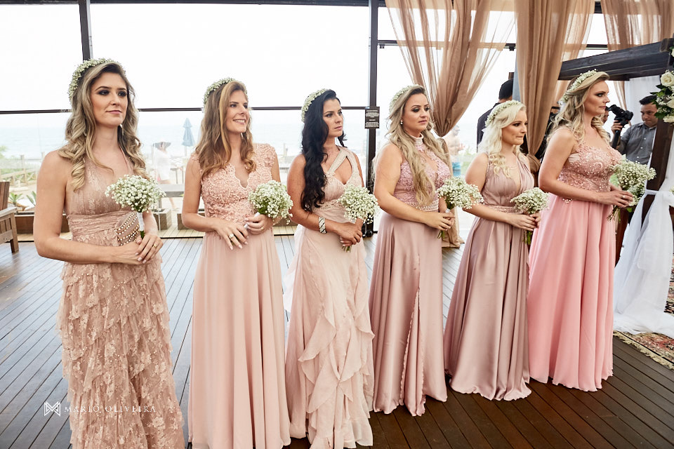 madrinhas com vestido da mesma cor, alinhadas ao lado do altar segurando buque