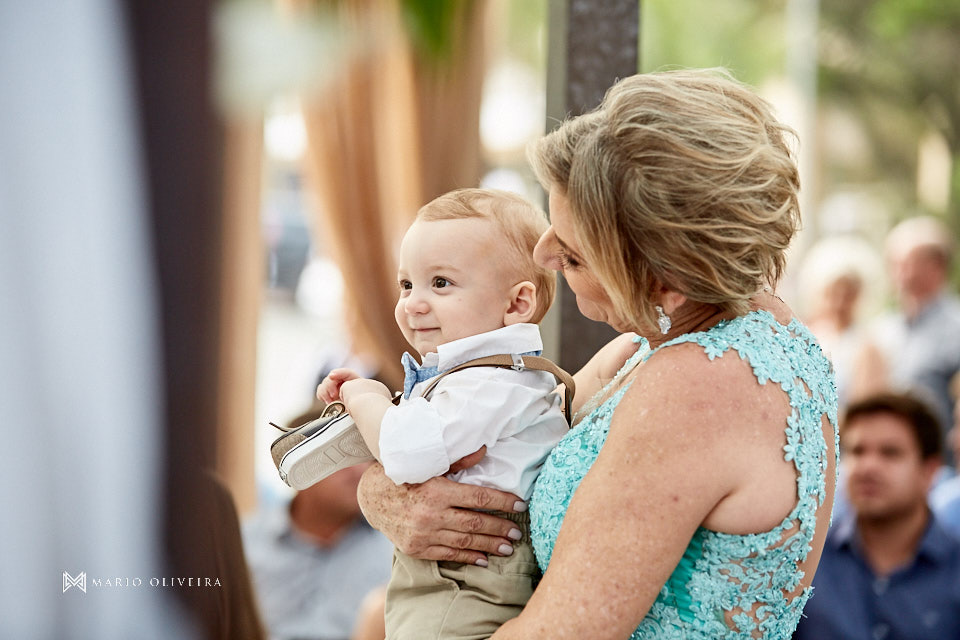 bebe segurando um pe de sapato no colo da mãe da noiva