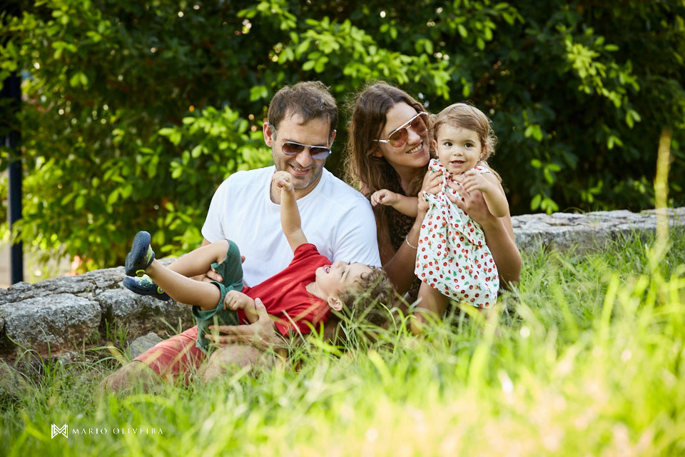famlia brincando na grama, pais e filhos sorrindo