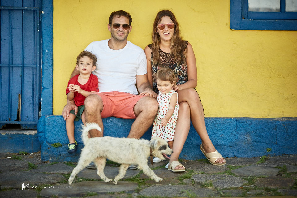 familia sentada se divertindo com um cachorro passando na frente