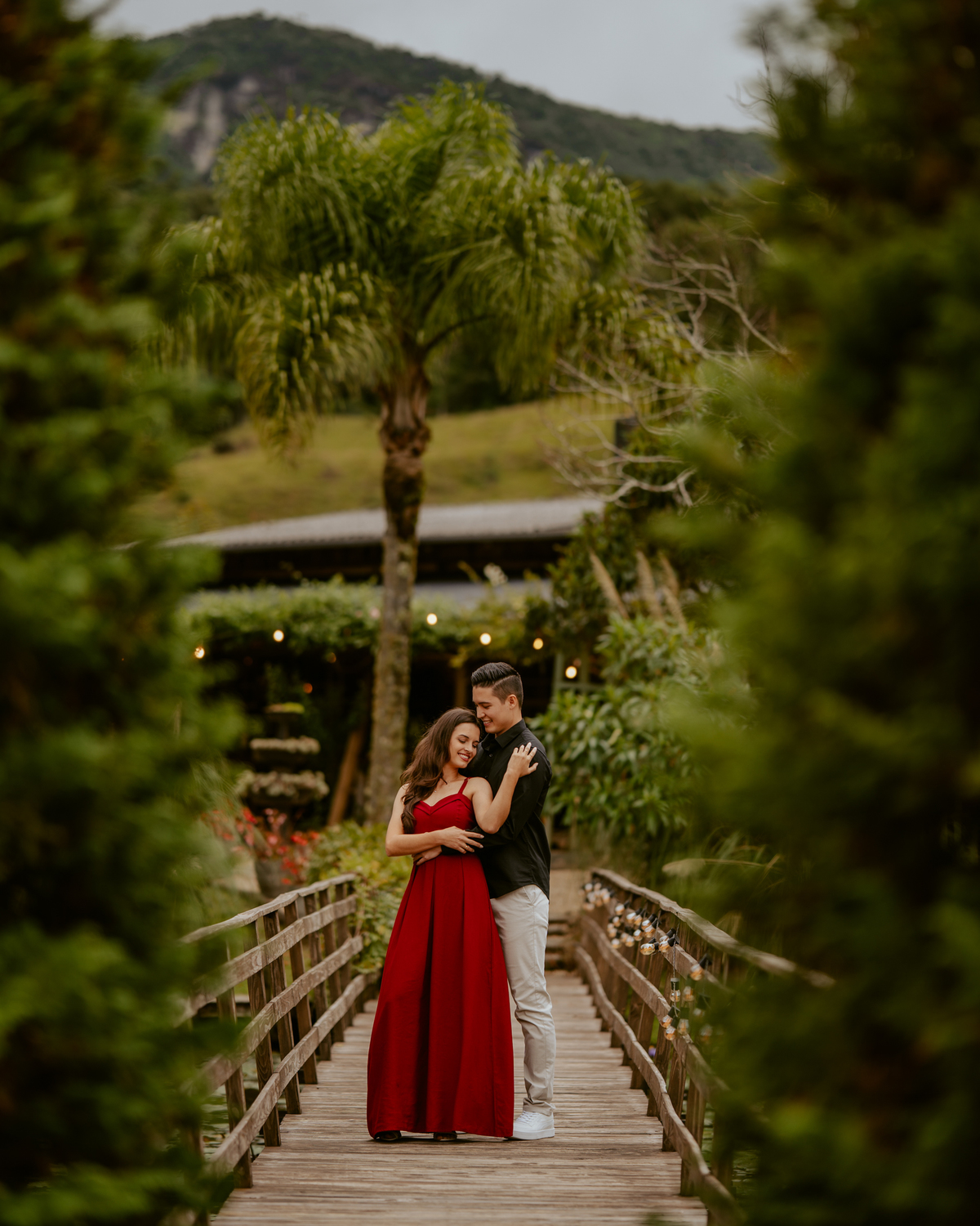 Fotografia de pré-wedding no Vale dos Ventos em Rio dos Cedros Santa Catarina com casal caminhando pelos jardins e lago durante ensaio pré-casamento em cenário natural na região serrana.