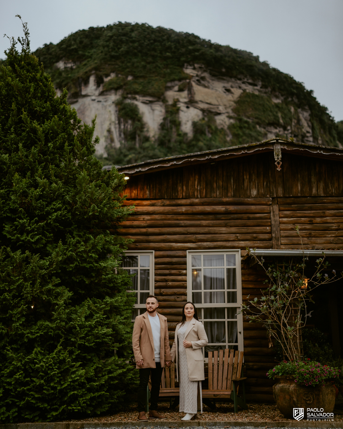 Casal em frente a casa rústica no Vale dos Ventos Rio dos Cedros SC, ensaio pré wedding elegante e romântico, fotógrafo de casamento Santa Catarina, fotos de casal estilo europeu pré casamento