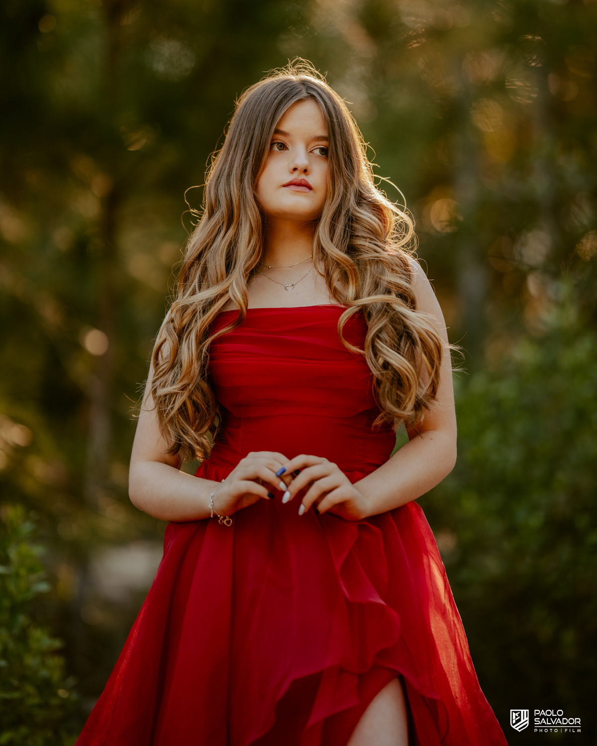 Retrato de debutante em ensaio de 15 anos em Florianópolis SC, menina com vestido vermelho e fundo desfocado na natureza, fotógrafo de debutante Santa Catarina, ensaio feminino ao ar livre Praia do Moçambique