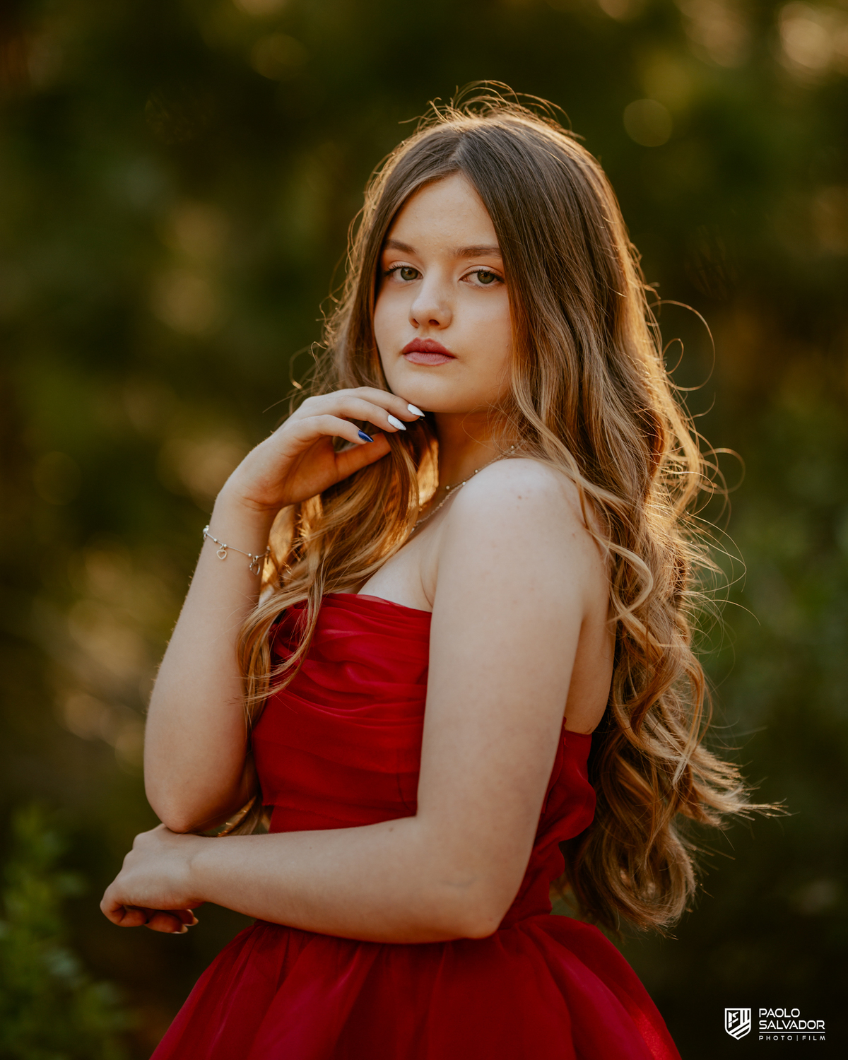 Retrato de debutante em ensaio de 15 anos em Florianópolis SC, menina com vestido vermelho e fundo desfocado na natureza, fotógrafo de debutante Santa Catarina, ensaio feminino ao ar livre Praia do Moçambique