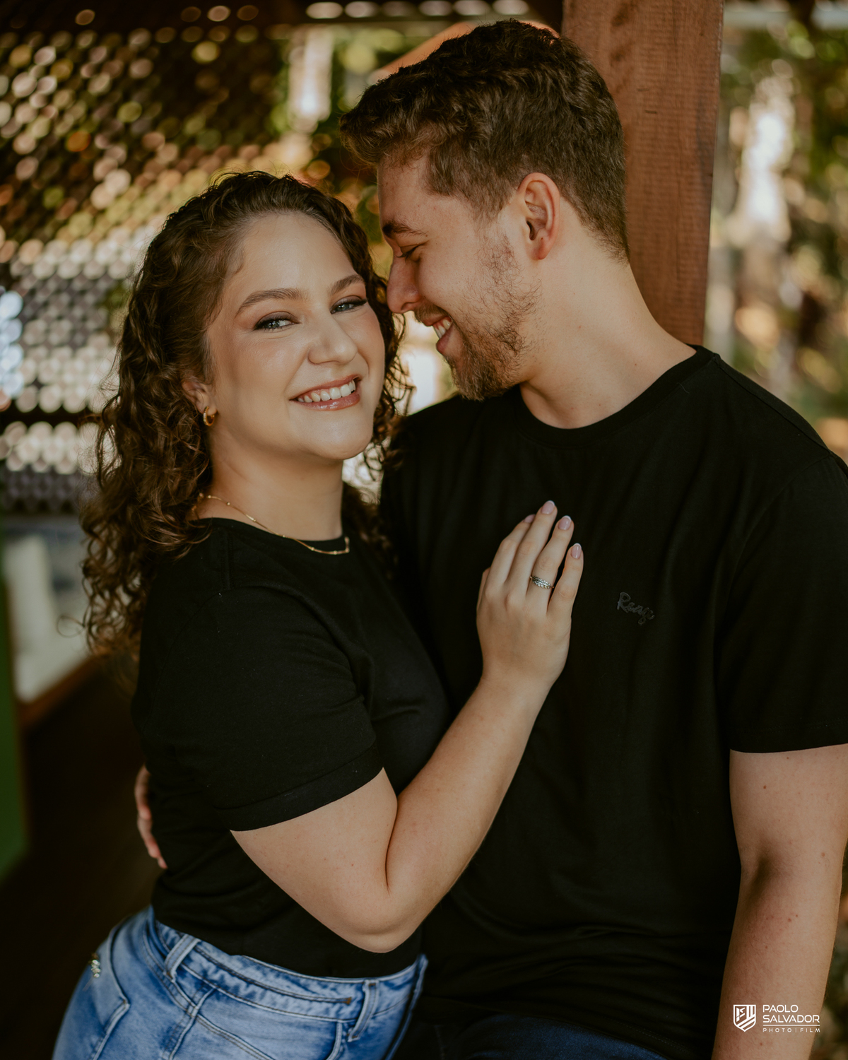 Casal em ensaio pré-wedding em Rio dos Cedros nas Cabanas Morro São Bernardo, abraçados em deck de madeira com natureza ao redor, luz suave e clima romântico, referência para ensaios na Barragem Rio Bonito, Palmeiras e Altos Cedros.