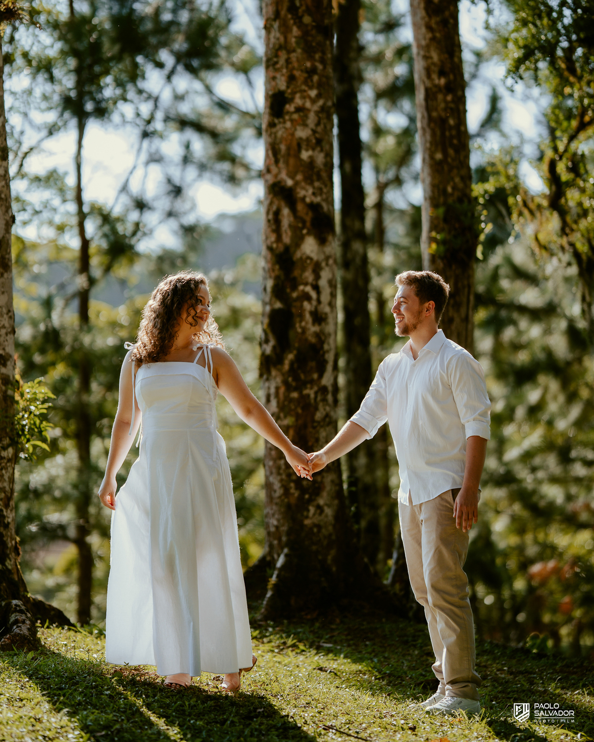 Casal abraçado em meio à natureza no Morro São Bernardo em Rio dos Cedros durante ensaio pré-wedding, com vegetação exuberante e atmosfera romântica típica da região de Altos Cedros e arredores.