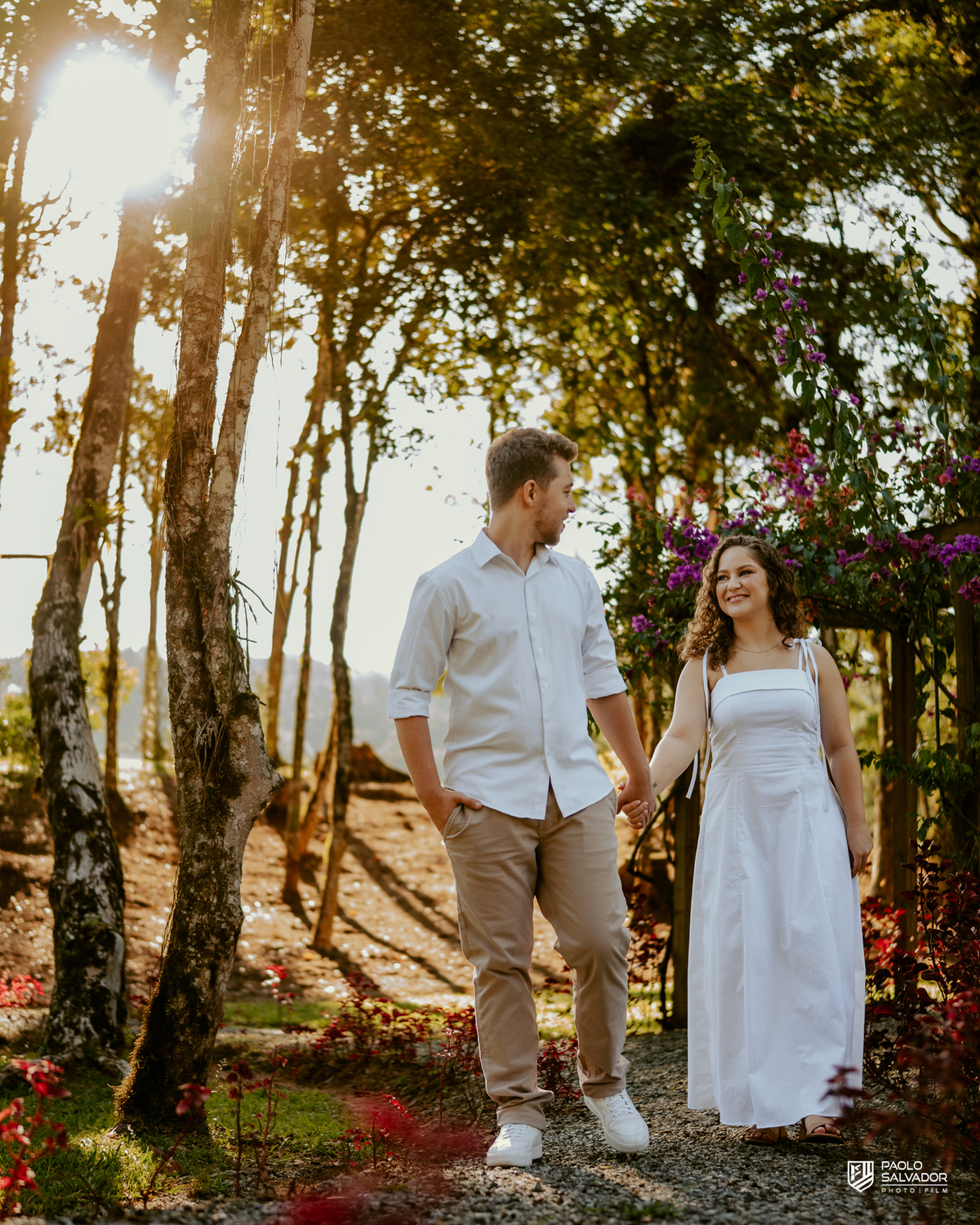 Casal abraçado em cerca de madeira no Morro São Bernardo em Rio dos Cedros durante ensaio pré-wedding, com luz suave e clima romântico, ideal para ensaios próximos às barragens.
