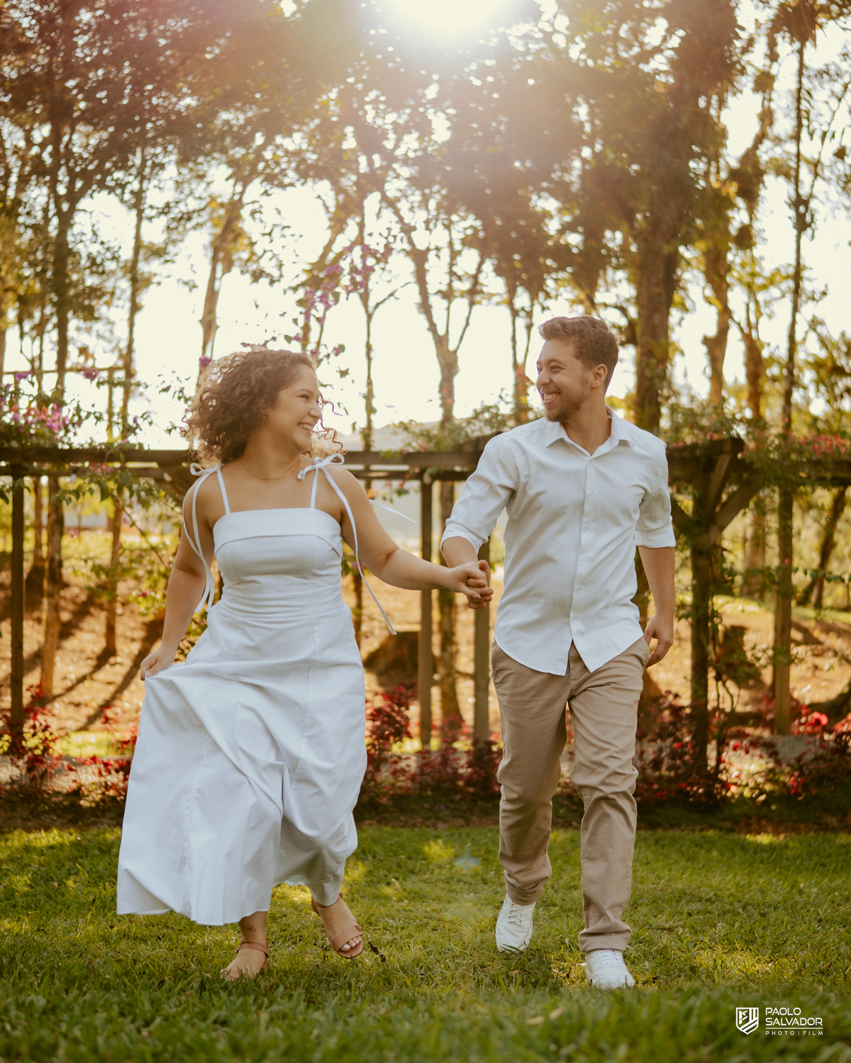 Casal abraçado em cerca de madeira no Morro São Bernardo em Rio dos Cedros durante ensaio pré-wedding, com luz suave e clima romântico, ideal para ensaios próximos às barragens.