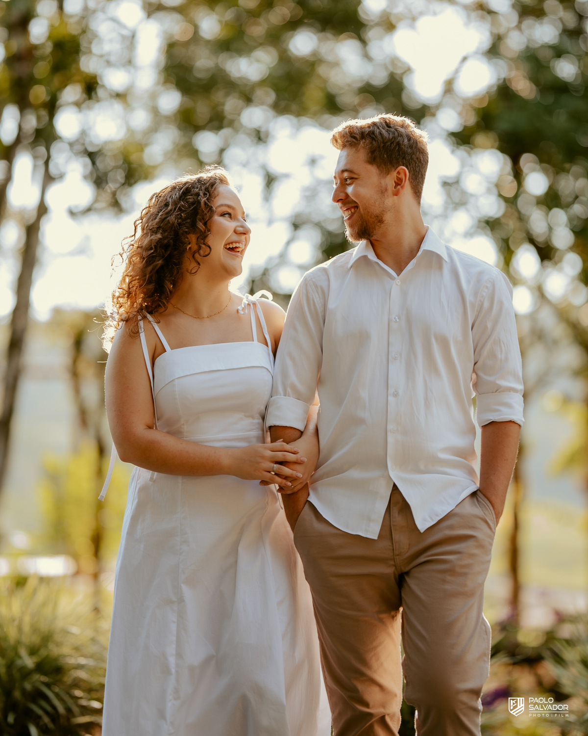 Casal abraçado em cerca de madeira no Morro São Bernardo em Rio dos Cedros durante ensaio pré-wedding, com luz suave e clima romântico, ideal para ensaios próximos às barragens.