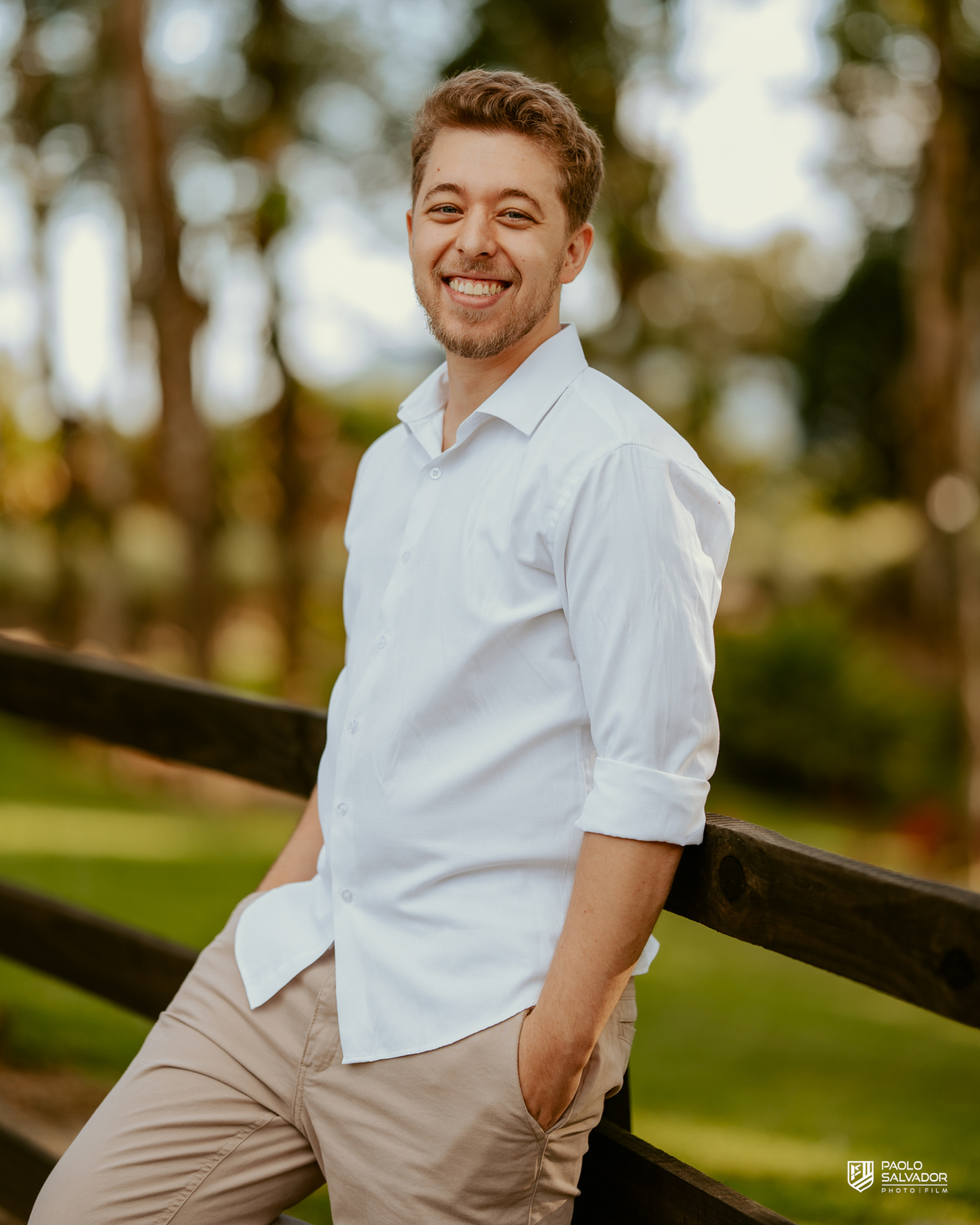 Casal abraçado em cerca de madeira no Morro São Bernardo em Rio dos Cedros durante ensaio pré-wedding, com luz suave e clima romântico, ideal para ensaios próximos às barragens.