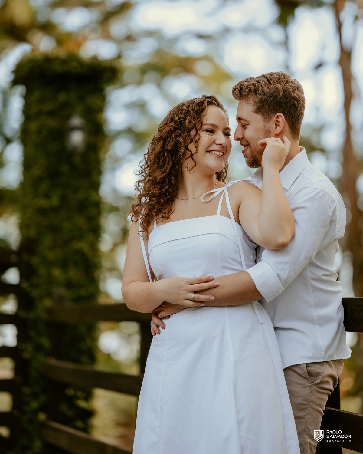 Casal posando em estrada cercada por árvores durante ensaio pré-wedding em Rio dos Cedros, com estética natural e romântica, referência para ensaios na Barragem Rio Bonito e Altos Cedros.