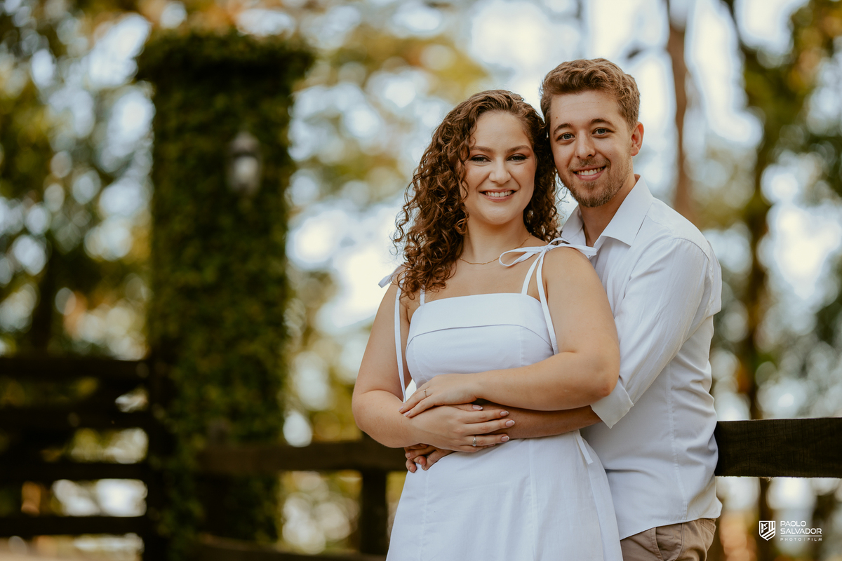 Casal posando em estrada cercada por árvores durante ensaio pré-wedding em Rio dos Cedros, com estética natural e romântica, referência para ensaios na Barragem Rio Bonito e Altos Cedros.