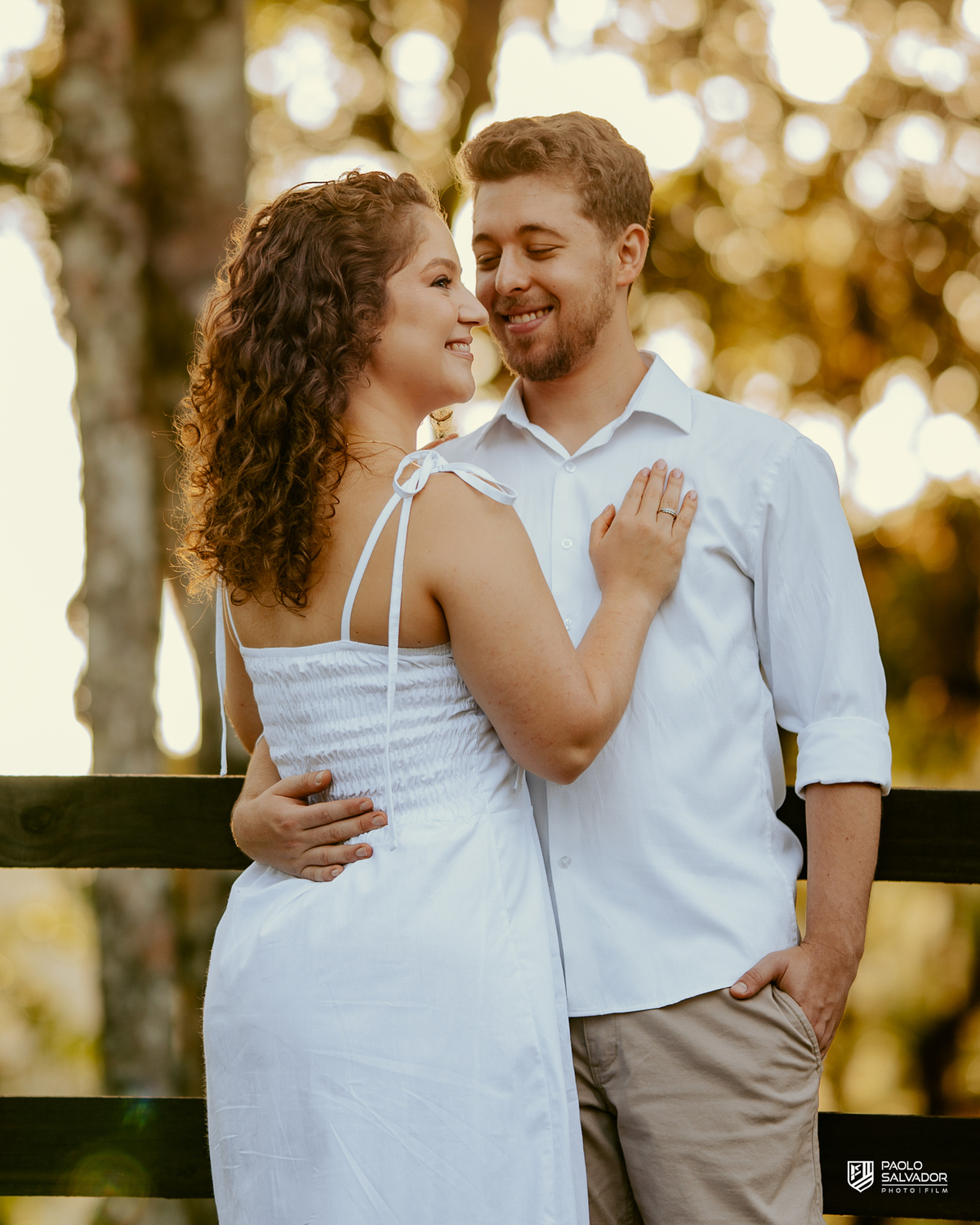 Casal posando em estrada cercada por árvores durante ensaio pré-wedding em Rio dos Cedros, com estética natural e romântica, referência para ensaios na Barragem Rio Bonito e Altos Cedros.