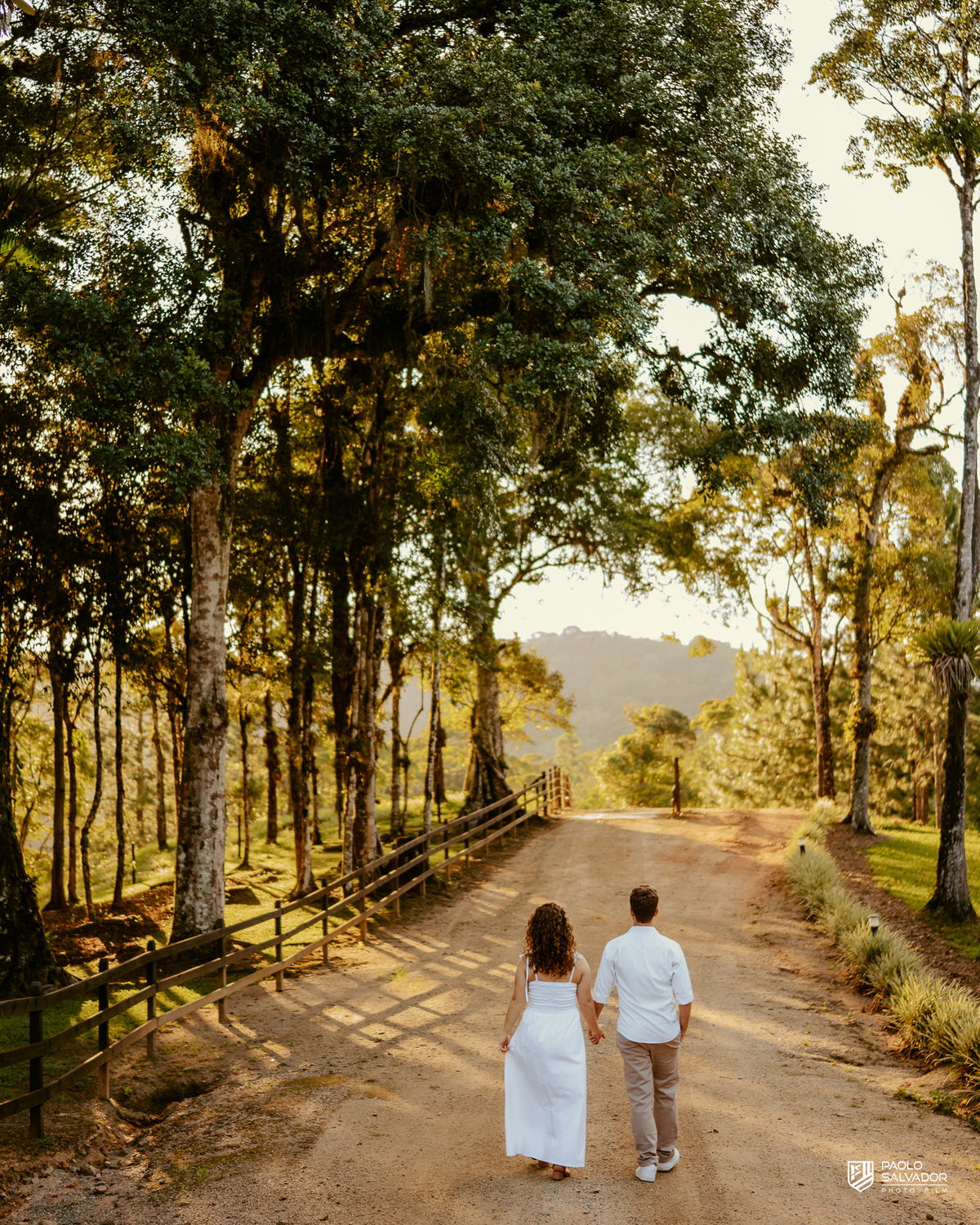 Casal caminhando juntos em estrada rural durante ensaio pré-wedding em Rio dos Cedros, com natureza ao redor e atmosfera leve, inspiração para ensaios em Altos Cedros e região das barragens.