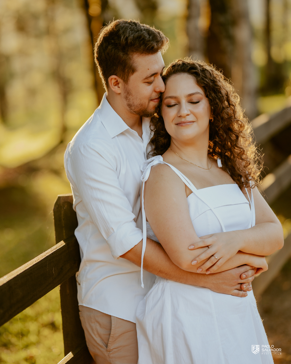 Casal sorrindo e abraçado em ensaio pré-wedding em Rio dos Cedros com fundo desfocado e luz dourada, destacando emoção e conexão, ideal para ensaios nas barragens e arredores.