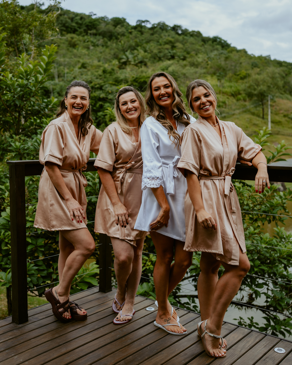 Noiva brindando com madrinhas no chalé do Refúgio dos Lagos em Massaranduba, momento descontraído e elegante antes da cerimônia, inspiração para casamentos em Joinville, Jaraguá e região.