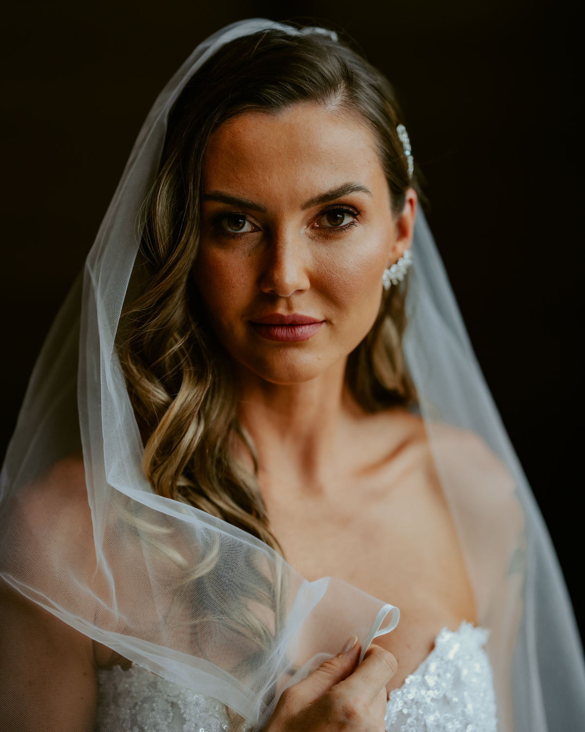 Noiva pronta com vestido de casamento e buquê dentro do chalé no Refúgio dos Lagos em Massaranduba, com luz natural e estética sofisticada, referência para casamentos na região.