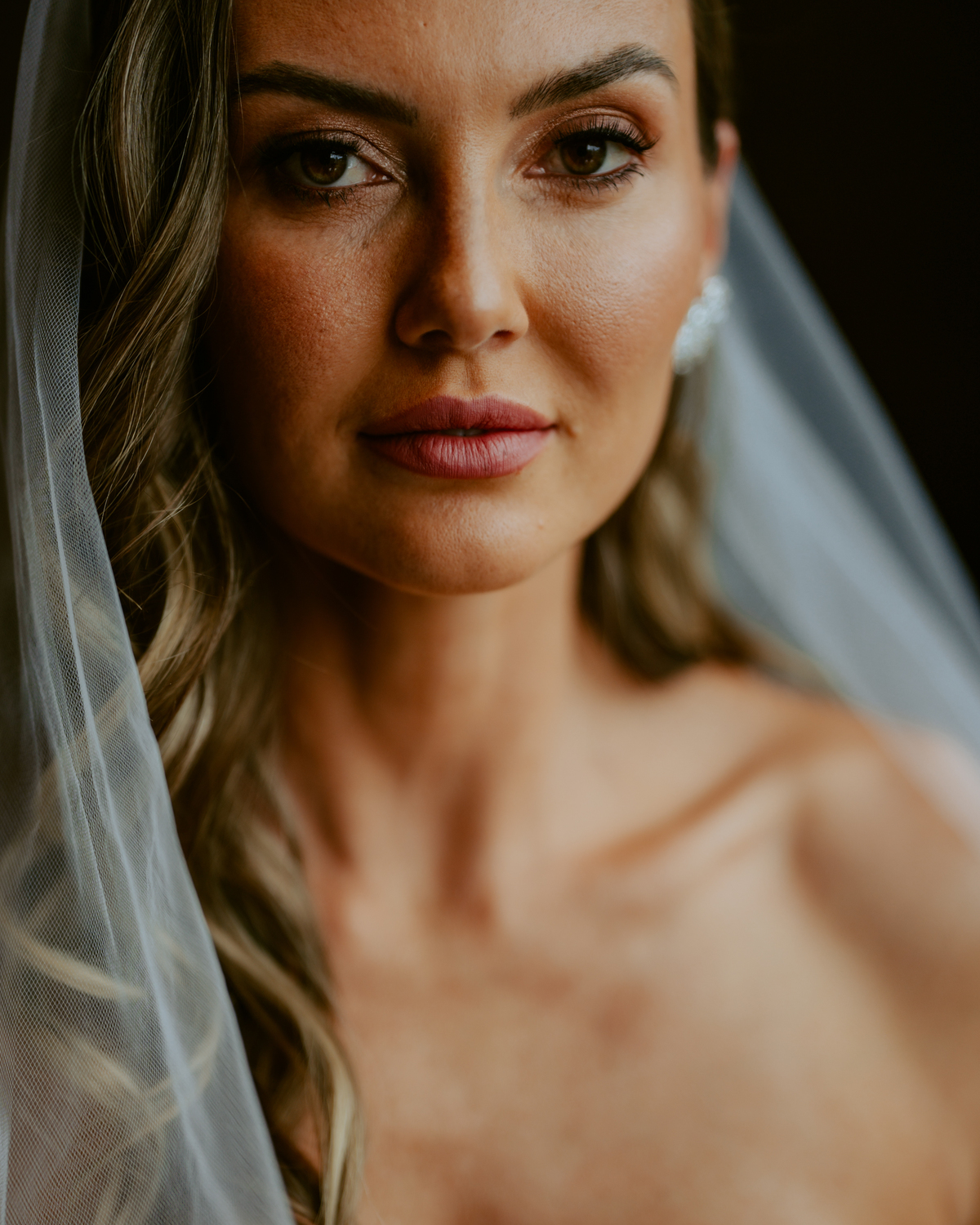 Noiva pronta com vestido de casamento e buquê dentro do chalé no Refúgio dos Lagos em Massaranduba, com luz natural e estética sofisticada, referência para casamentos na região.