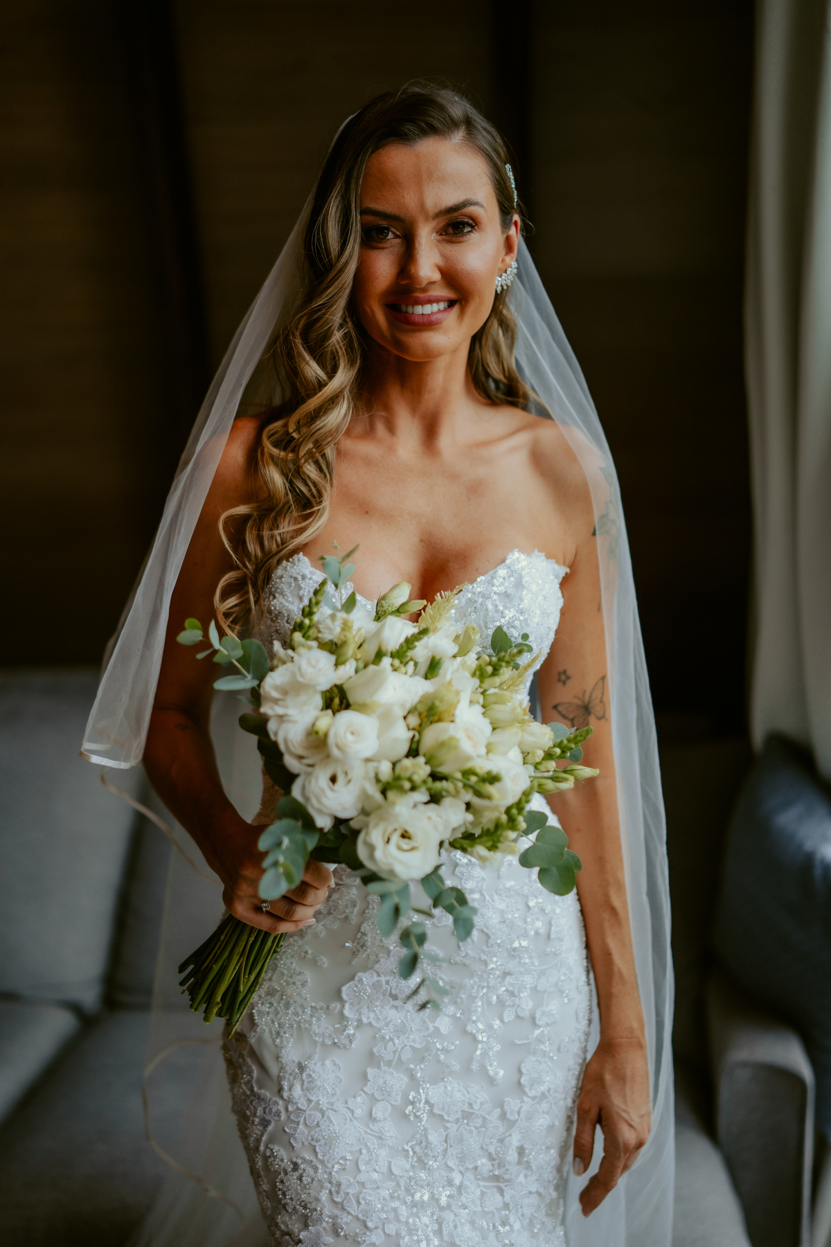 Noiva pronta com vestido de casamento e buquê dentro do chalé no Refúgio dos Lagos em Massaranduba, com luz natural e estética sofisticada, referência para casamentos na região.