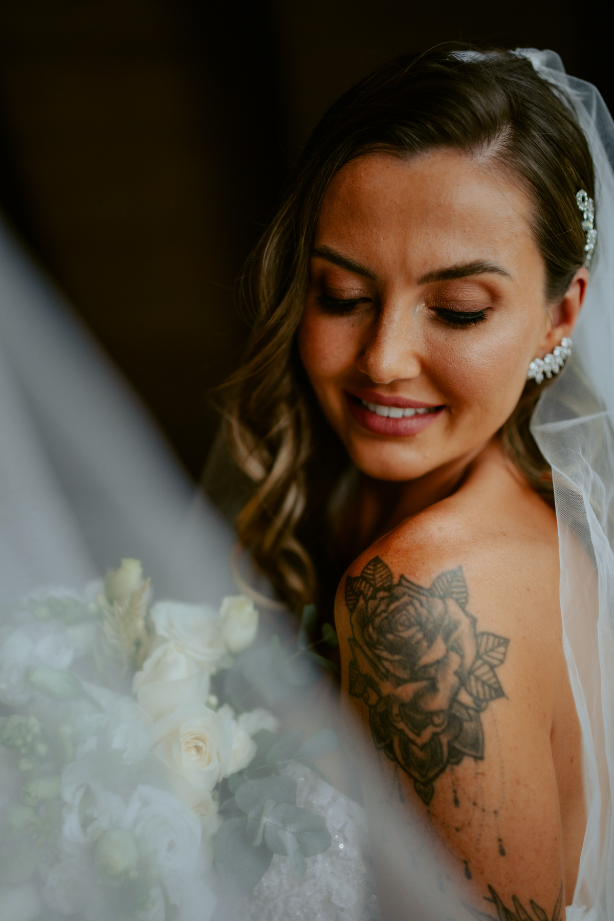 Noiva pronta com vestido de casamento e buquê dentro do chalé no Refúgio dos Lagos em Massaranduba, com luz natural e estética sofisticada, referência para casamentos na região.