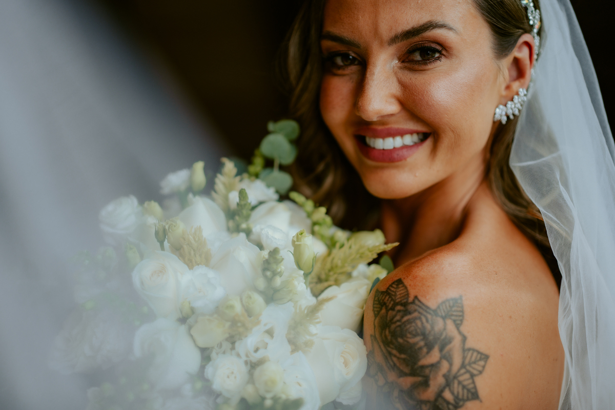 Noiva pronta com vestido de casamento e buquê dentro do chalé no Refúgio dos Lagos em Massaranduba, com luz natural e estética sofisticada, referência para casamentos na região.