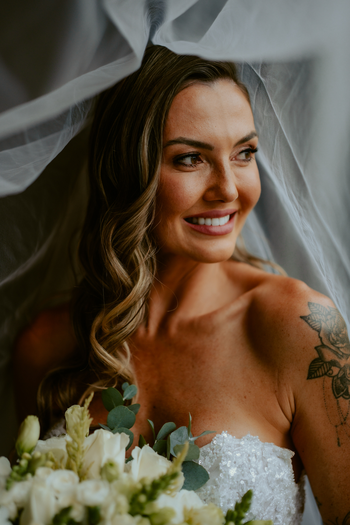 Noiva pronta com vestido de casamento e buquê dentro do chalé no Refúgio dos Lagos em Massaranduba, com luz natural e estética sofisticada, referência para casamentos na região.