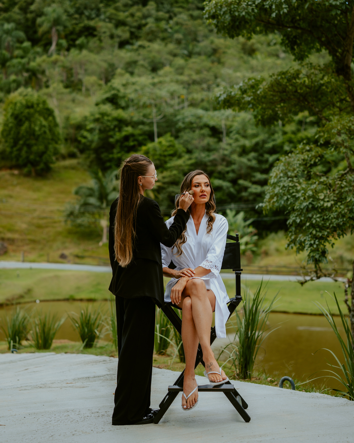 Noiva sendo maquiada no chalé do Refúgio dos Lagos em Massaranduba durante making of de casamento, com natureza ao fundo, preparação elegante e clima intimista, ideal para casamentos em Joinville, Jaraguá do Sul e Luiz Alves.