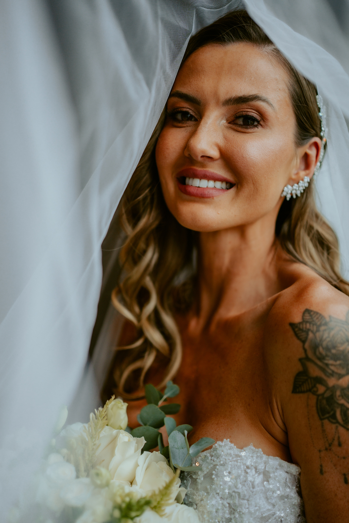 Noiva pronta com vestido de casamento e buquê dentro do chalé no Refúgio dos Lagos em Massaranduba, com luz natural e estética sofisticada, referência para casamentos na região.