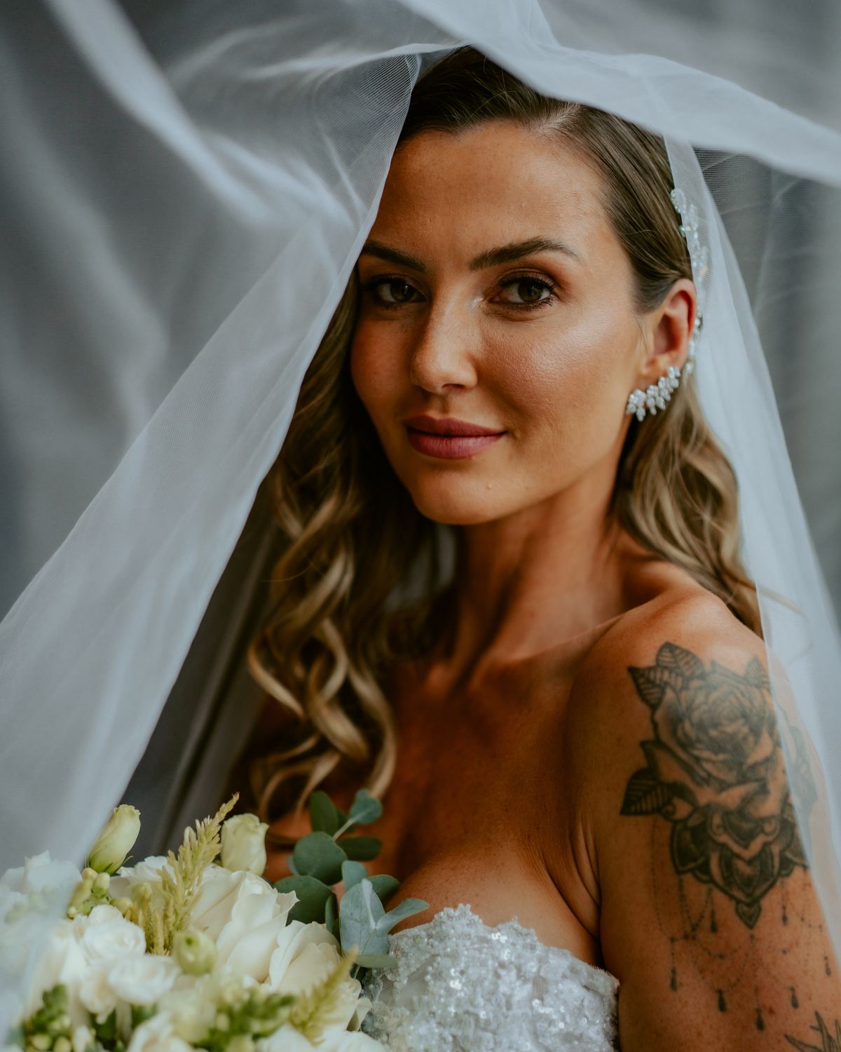 Noiva pronta com vestido de casamento e buquê dentro do chalé no Refúgio dos Lagos em Massaranduba, com luz natural e estética sofisticada, referência para casamentos na região.