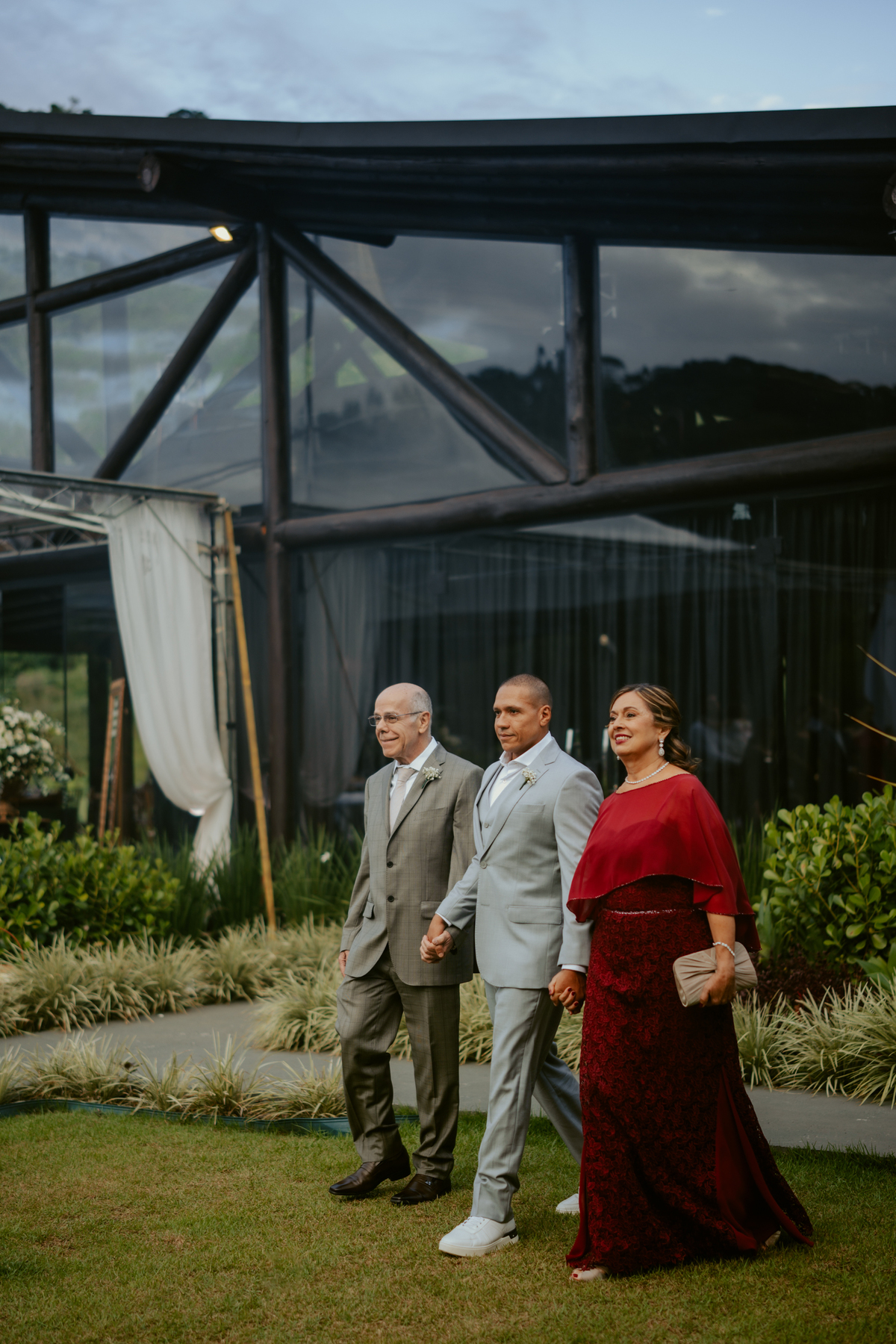 Entrada do noivo com familiares durante cerimônia de casamento ao ar livre no Refúgio dos Lagos em Massaranduba, com convidados e decoração natural.