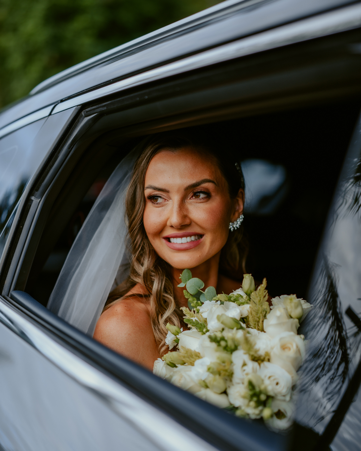 Noiva entrando na cerimônia acompanhada de familiares em casamento ao ar livre no Refúgio dos Lagos em Massaranduba, com convidados emocionados e cenário natural.