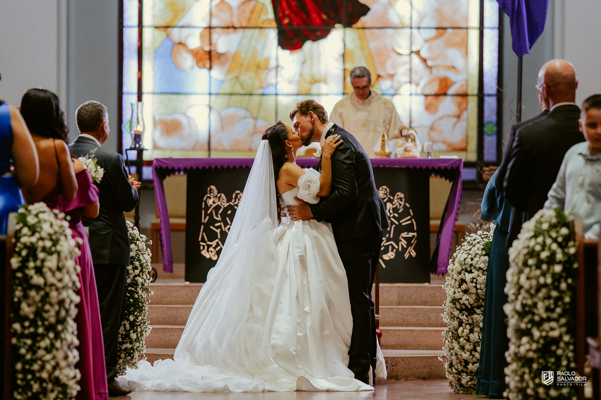 Noivos em retrato romântico dentro da Igreja Santa Inês com vitral ao fundo, fotografia de casamento elegante, ensaio pós-cerimônia Indaial