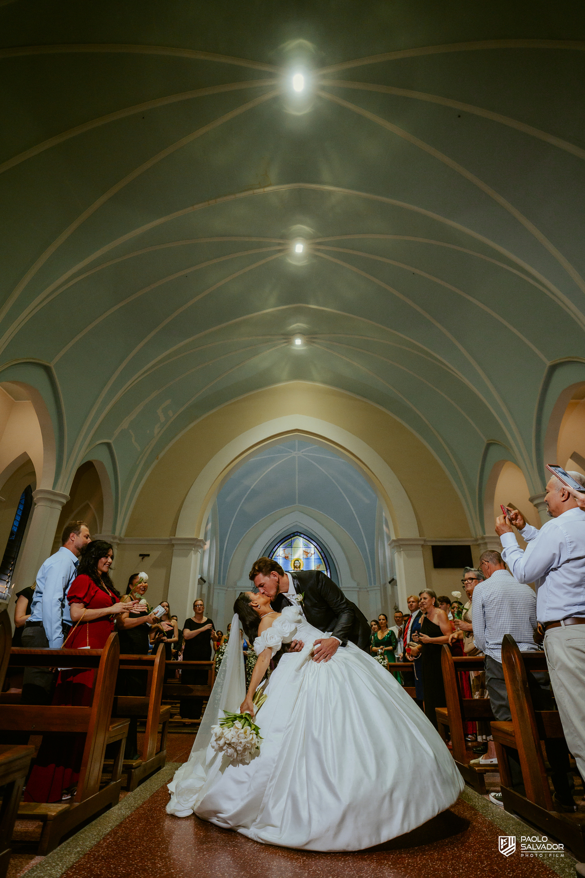Noivos em retrato romântico dentro da Igreja Santa Inês com vitral ao fundo, fotografia de casamento elegante, ensaio pós-cerimônia Indaial