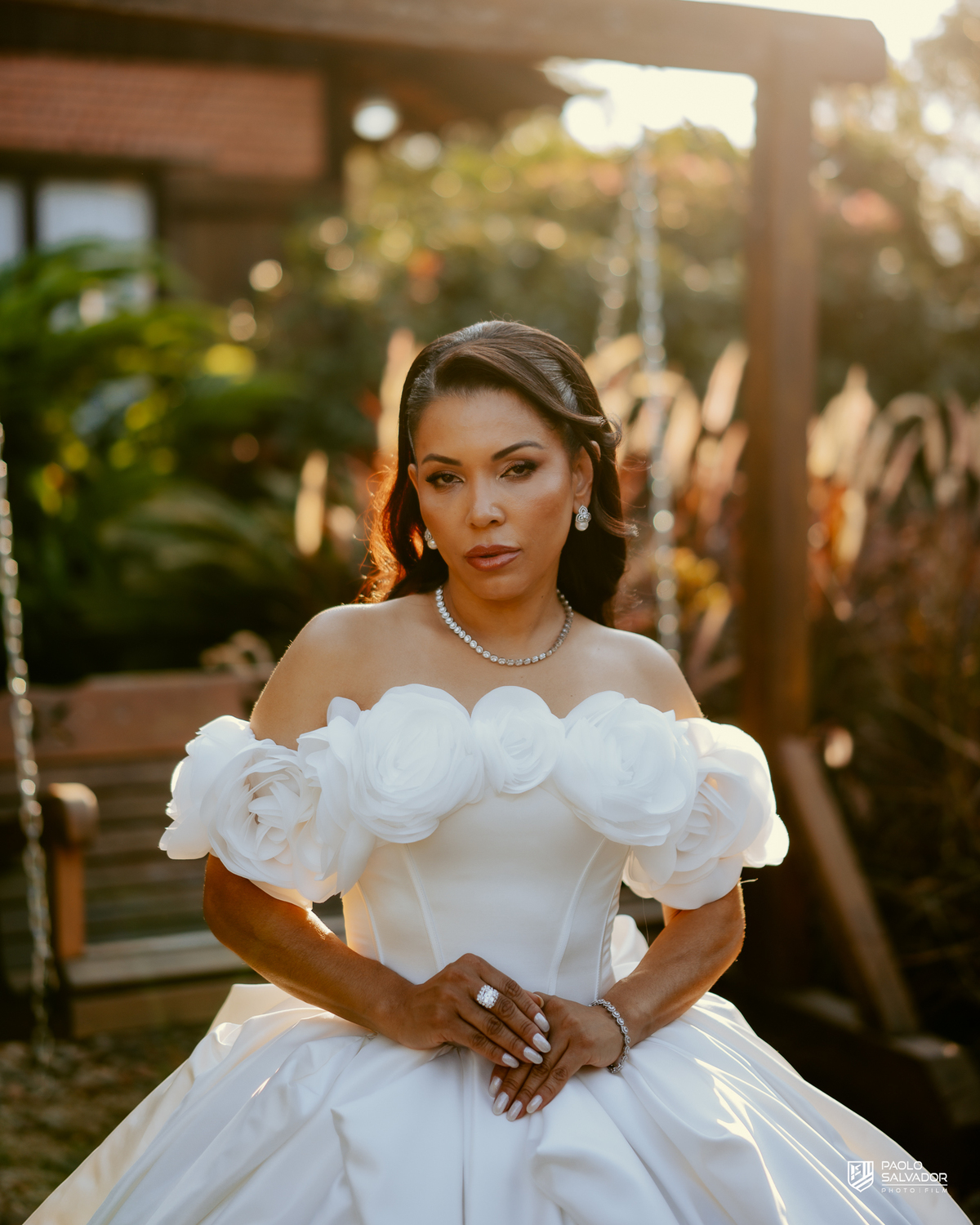Noiva com vestido de luxo em ensaio na decoração externa com luz dourada, Sociedade Recreativa Indaial, tendência ensaio noiva pronta, fotografia de casamento premium Santa Catarina