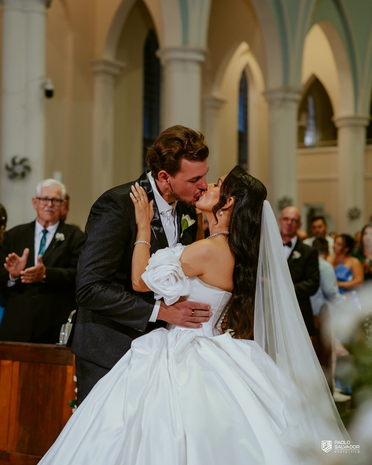 Noivos em retrato romântico dentro da Igreja Santa Inês com vitral ao fundo, fotografia de casamento elegante, ensaio pós-cerimônia Indaial