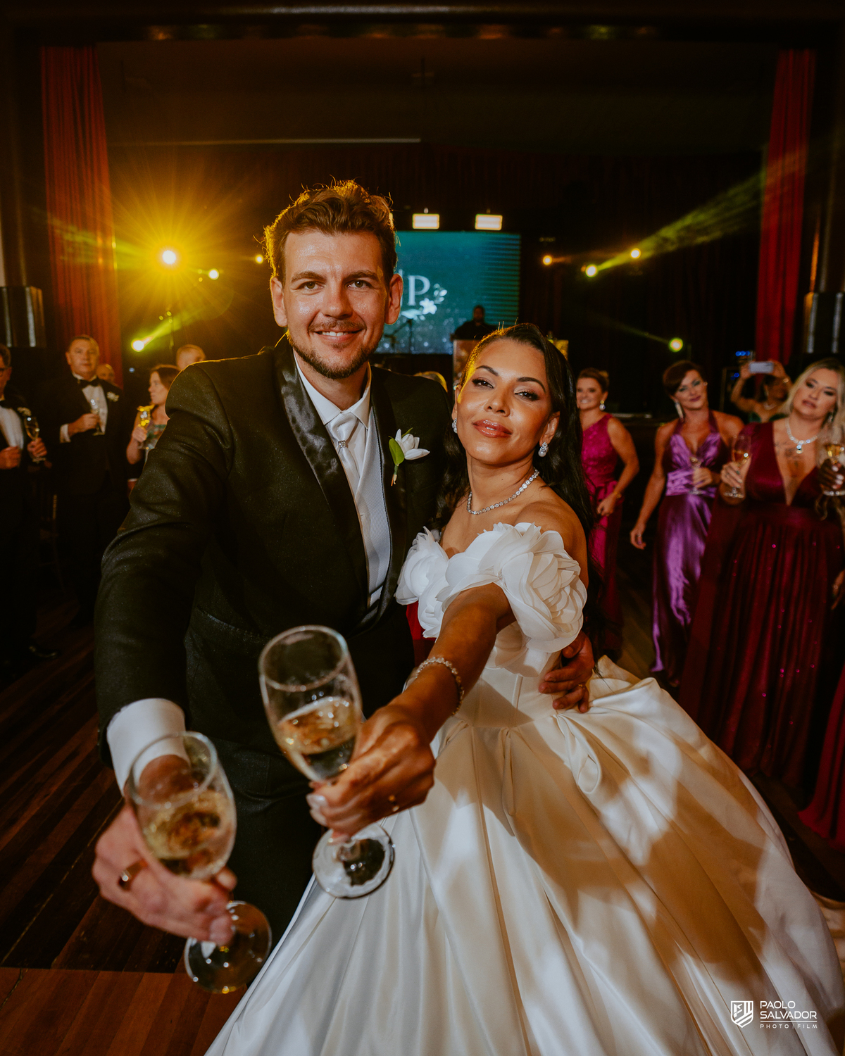 Noivos brindando com convidados na pista de dança na Sociedade Recreativa Indaial, festa de casamento animada com DJ Evandro Kern, fotografia de casamento festa SC