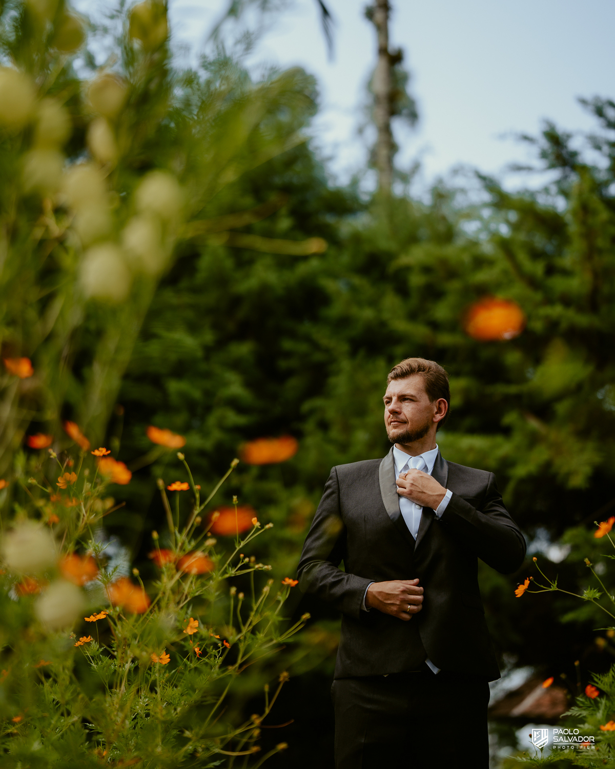 Noivo Rogério ajustando o terno em meio à natureza no Sítio Colina Verde em Indaial, making of do noivo com estilo elegante, fotografia de casamento em Indaial, ensaio masculino ao ar livre, fotógrafo de casamento Santa Catarina