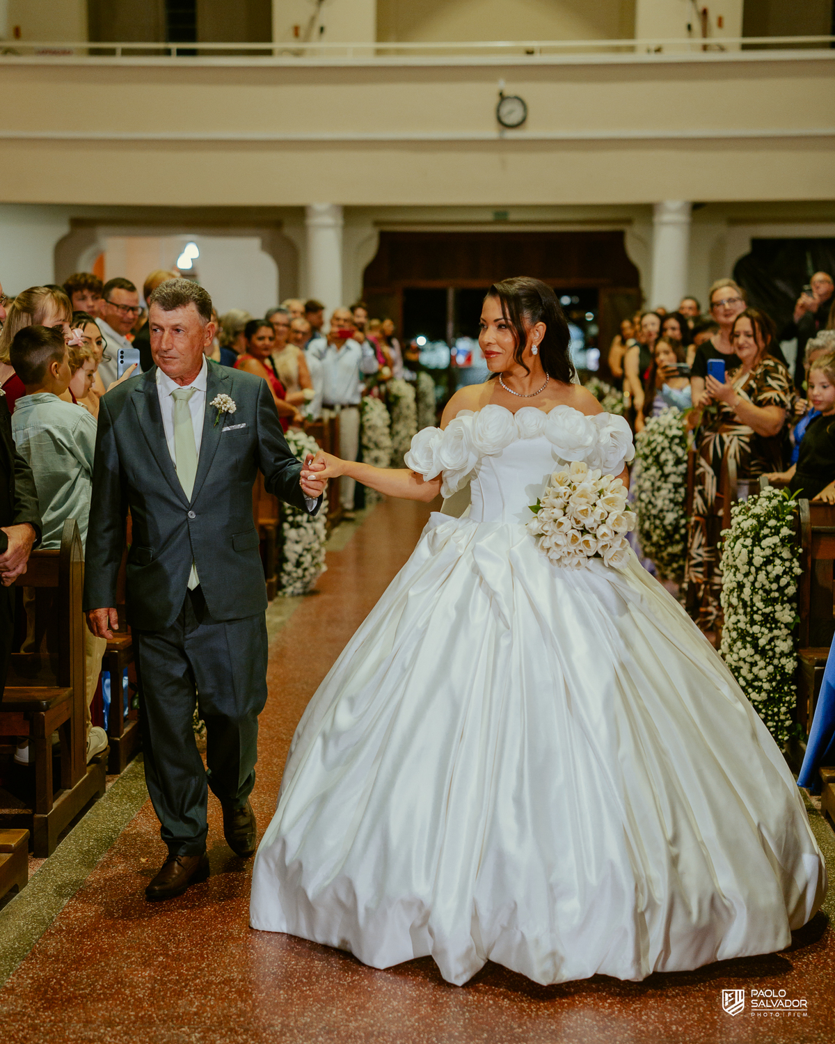 Noivo e noiva entrando juntos na Igreja Santa Inês em Indaial, cerimônia de casamento emocionante, fotografia documental de casamento Santa Catarina