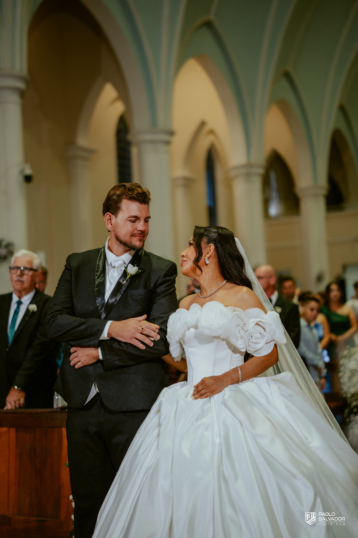 Noivo e noiva entrando juntos na Igreja Santa Inês em Indaial, cerimônia de casamento emocionante, fotografia documental de casamento Santa Catarina