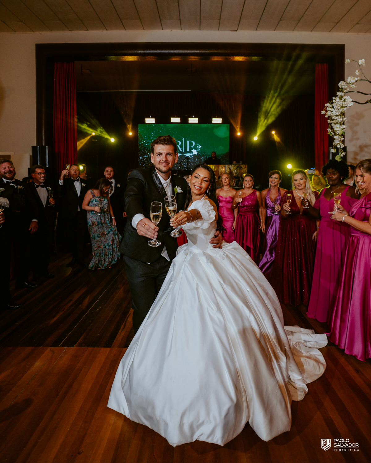Noivos brindando com convidados na pista de dança na Sociedade Recreativa Indaial, festa de casamento animada com DJ Evandro Kern, fotografia de casamento festa SC