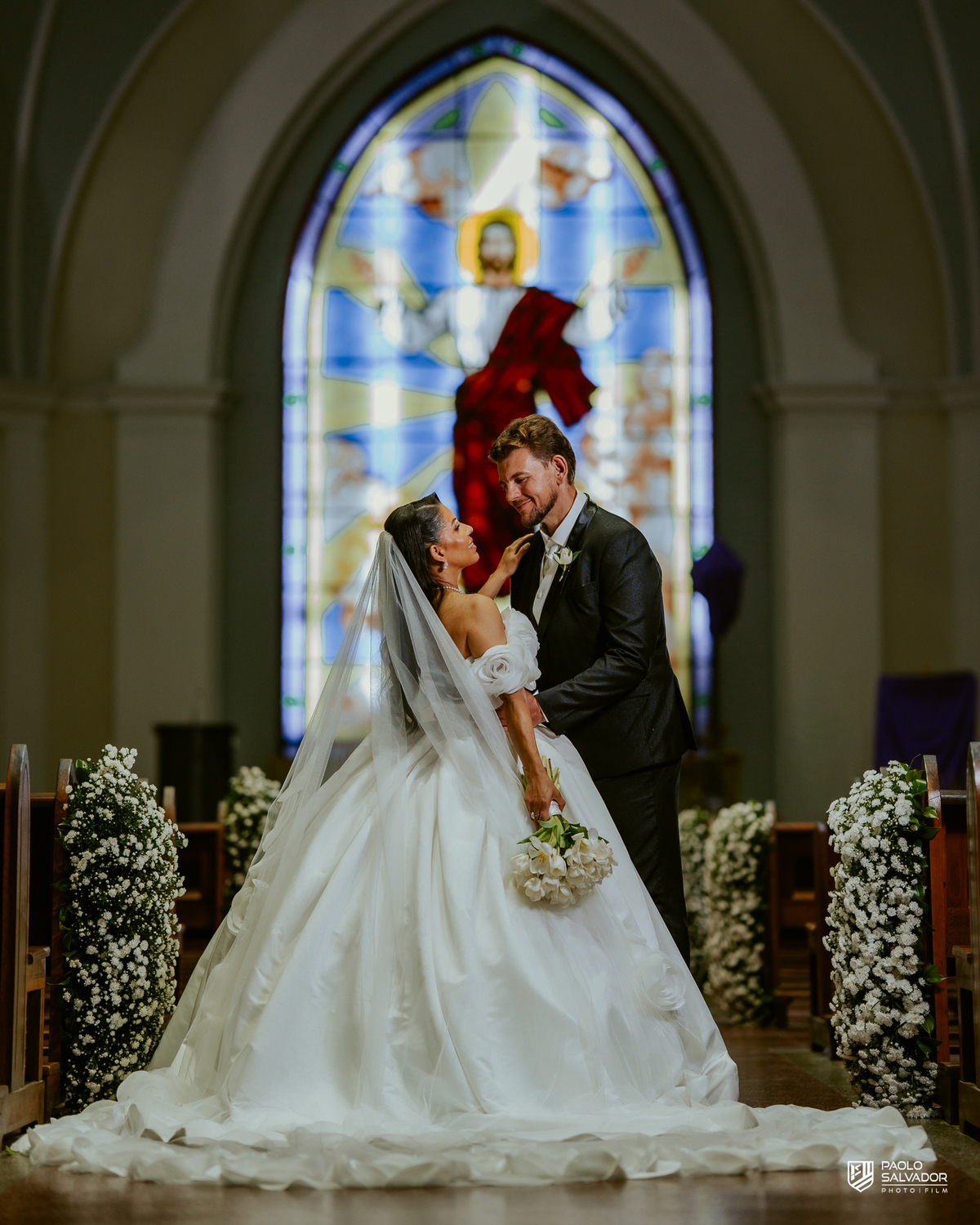 Noivos em frente à igreja com carro clássico branco, ensaio pós-cerimônia em Indaial, fotografia de casamento sofisticada Santa Catarina