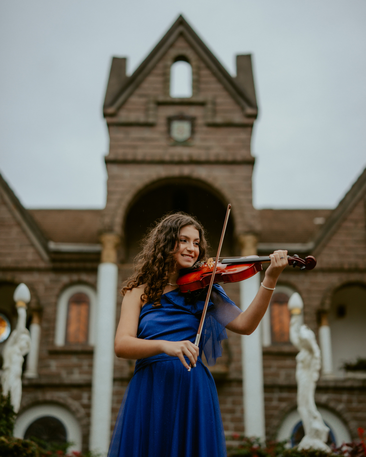 Ensaio de 15 anos debutante no Castelo Belvedere em 13 de Maio Santa Catarina, fotos de debutante em jardim, escadaria, charrete e castelo, ensaio feminino elegante com vestido azul e rosa, fotografia profissional de 15 anos com vestido princesa 