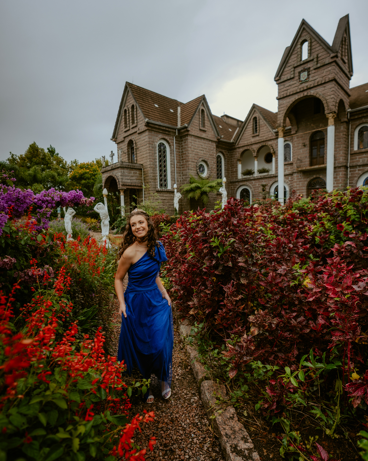 Ensaio de 15 anos debutante no Castelo Belvedere em 13 de Maio Santa Catarina, fotos de debutante em jardim, escadaria, charrete e castelo, ensaio feminino elegante com vestido azul e rosa, fotografia profissional de 15 anos com vestido princesa 
