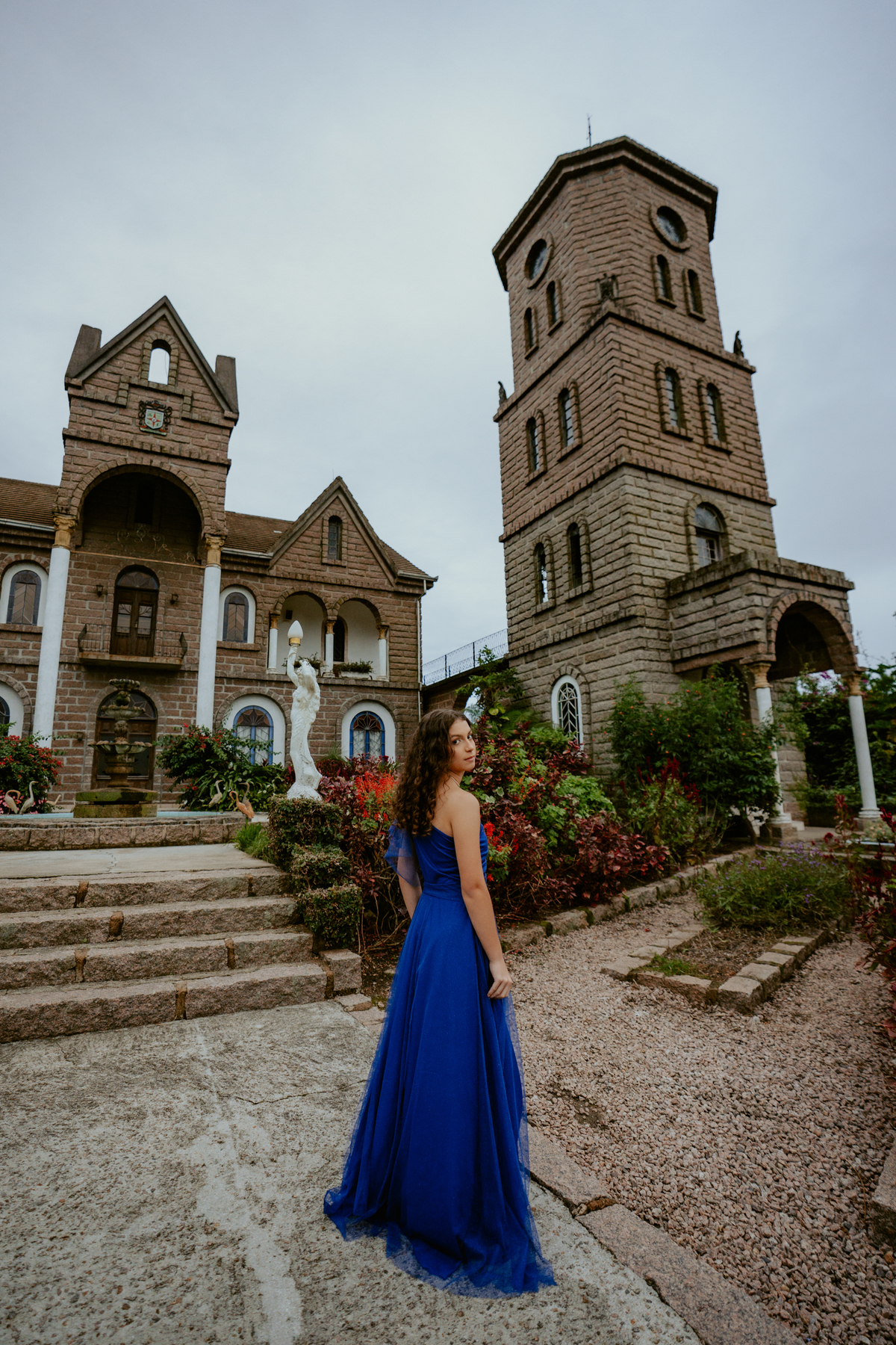 Ensaio de 15 anos debutante no Castelo Belvedere em 13 de Maio Santa Catarina, fotos de debutante em jardim, escadaria, charrete e castelo, ensaio feminino elegante com vestido azul e rosa, fotografia profissional de 15 anos com vestido princesa 