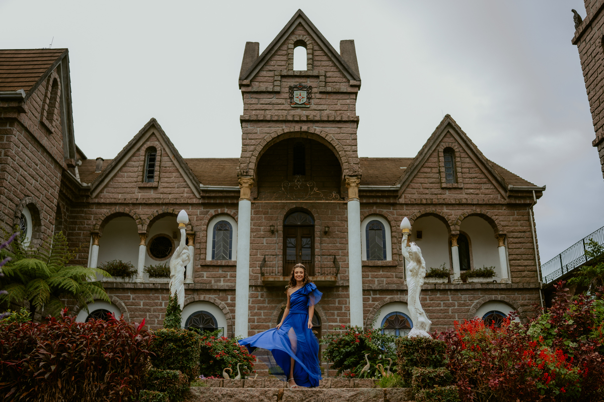 Ensaio de 15 anos debutante no Castelo Belvedere em 13 de Maio Santa Catarina, fotos de debutante em jardim, escadaria, charrete e castelo, ensaio feminino elegante com vestido azul e rosa, fotografia profissional de 15 anos com vestido princesa 