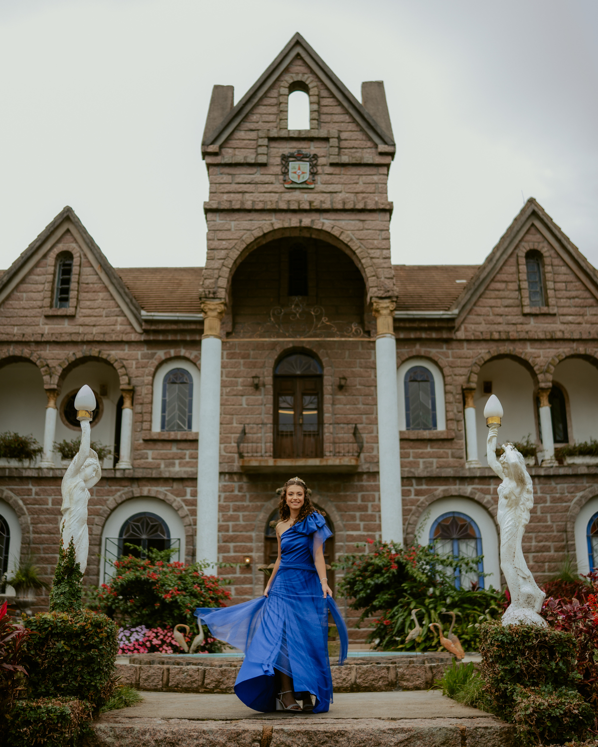Ensaio de 15 anos debutante no Castelo Belvedere em 13 de Maio Santa Catarina, fotos de debutante em jardim, escadaria, charrete e castelo, ensaio feminino elegante com vestido azul e rosa, fotografia profissional de 15 anos com vestido princesa 